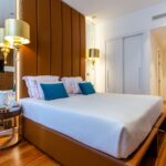 Home Elegant modern hotel room with plush bedding and warm lighting in Lisbon, Portugal.