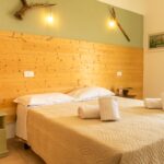 Home Inviting hotel bedroom featuring wooden decor and soft lighting, perfect for relaxation.