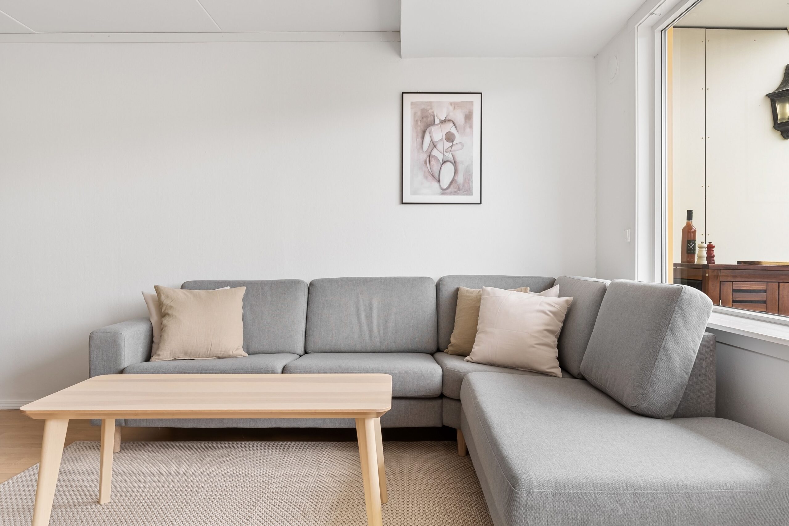 Home A cozy and modern living room featuring a grey sofa and wooden coffee table.
