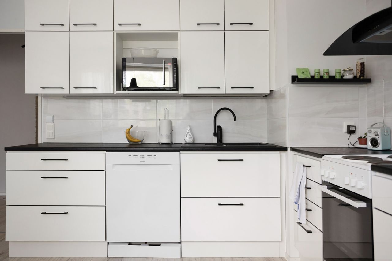 Sleek and modern white kitchen with appliances, showcasing contemporary interior design.