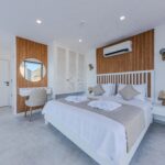 Home Spacious and airy modern bedroom featuring a double bed and stylish furnishings.