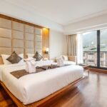 Home Luxurious hotel bedroom with a view of mountains through large window.