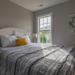 Home A warm, inviting bedroom with a double bed and natural light streaming in.