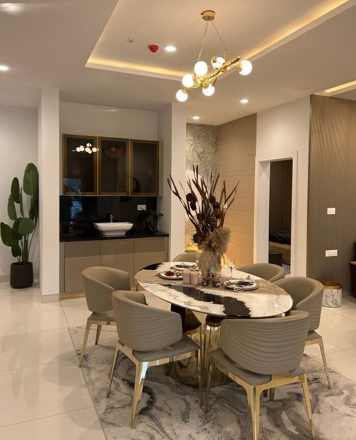 Stylish dining area with marble table, chic chairs, and artistic lighting in a modern setting.
