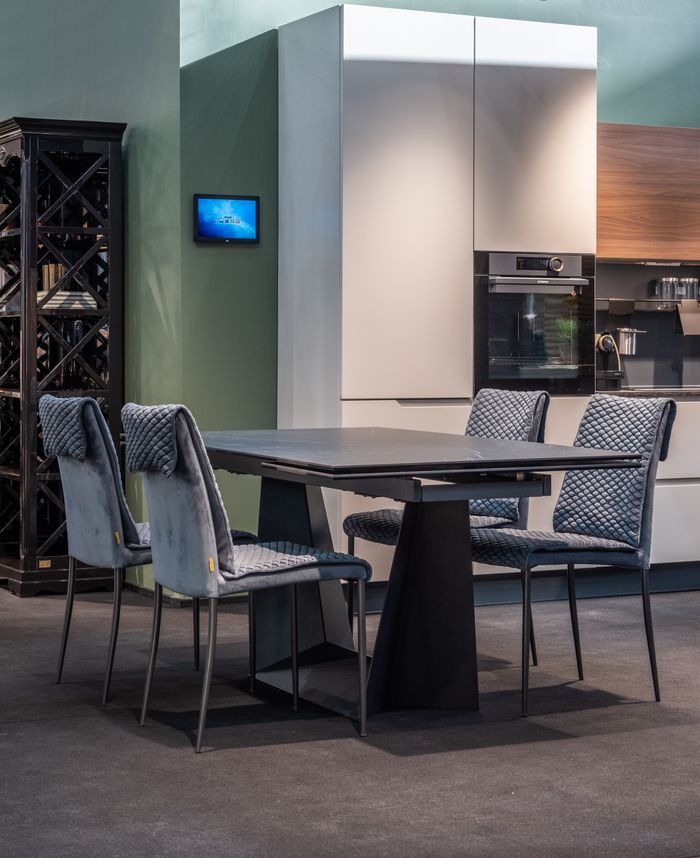 Interior of stylish kitchen with modern furniture and appliances with dining table with chairs
