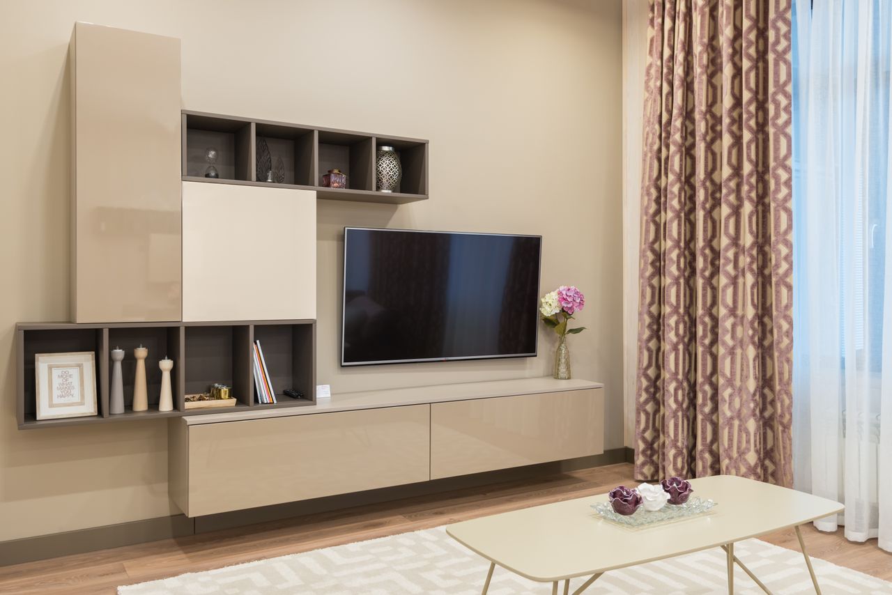 Tv unit Minimalist interior of contemporary living room with TV set and cabinet decorated with flowers and vases