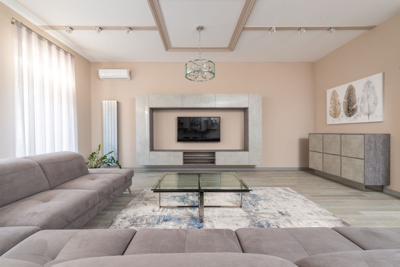 Tv unit Interior of contemporary living room with glass table and sofa near windows and TV on wall