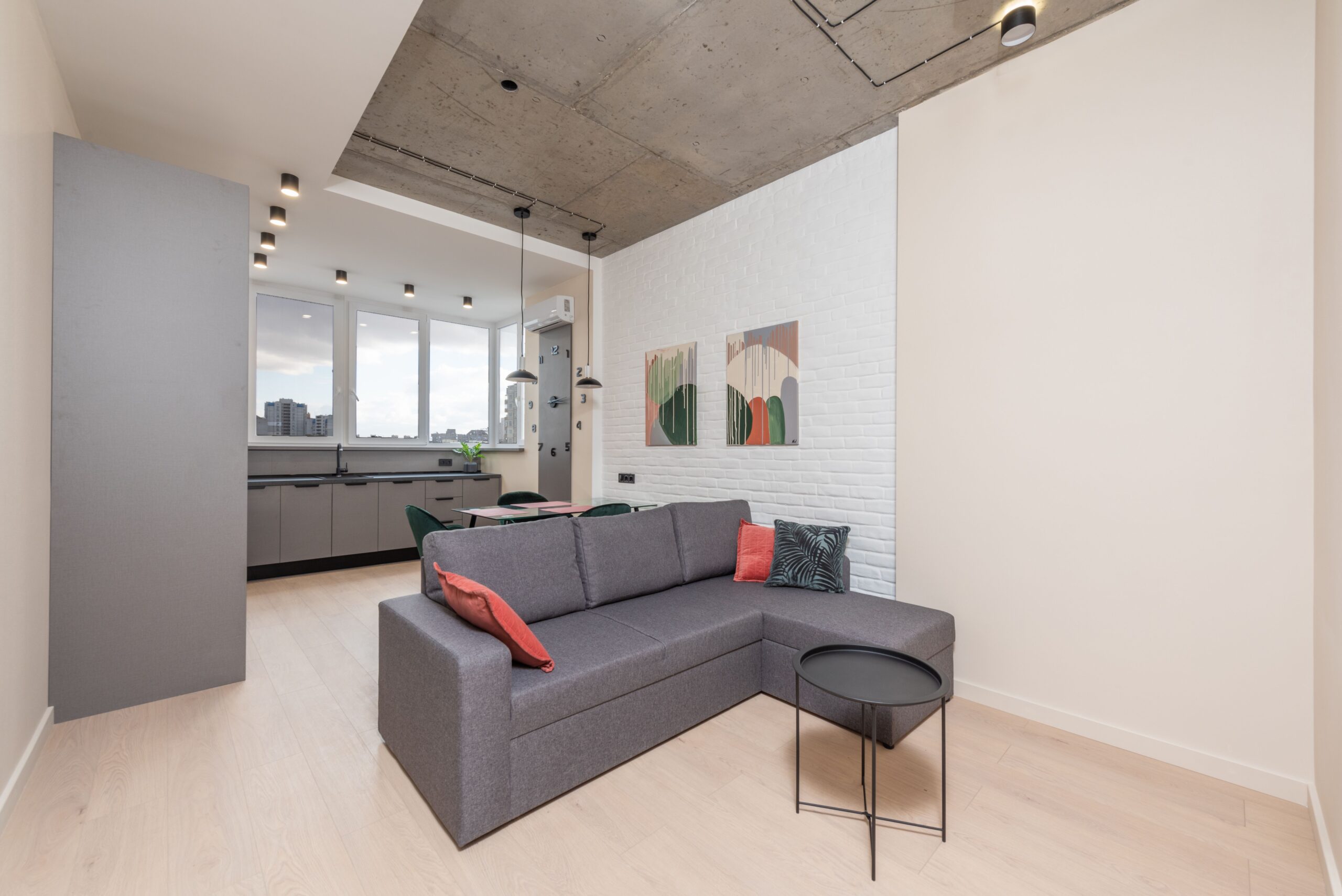 Home Interior of lounge with comfortable sofa and kitchen with dining table and counter in new open plan flat