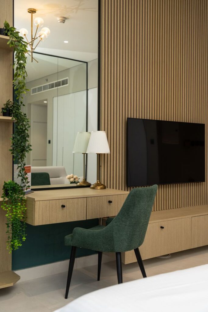 Contemporary room featuring wooden paneling, smart TV, and green accents in Dubai hotel.