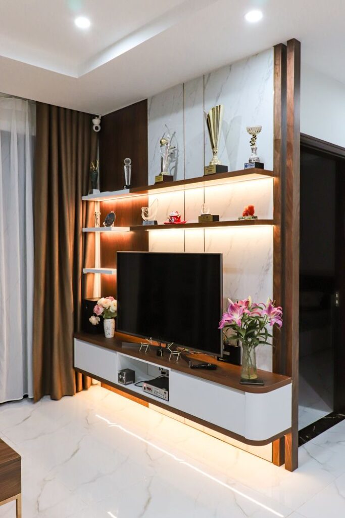 Elegant living room featuring a sleek TV stand, trophies, and ambient lighting.