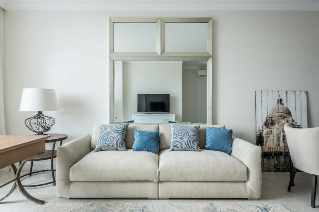 Comfortable couch with soft pillows located in cozy living room with furniture and carpet